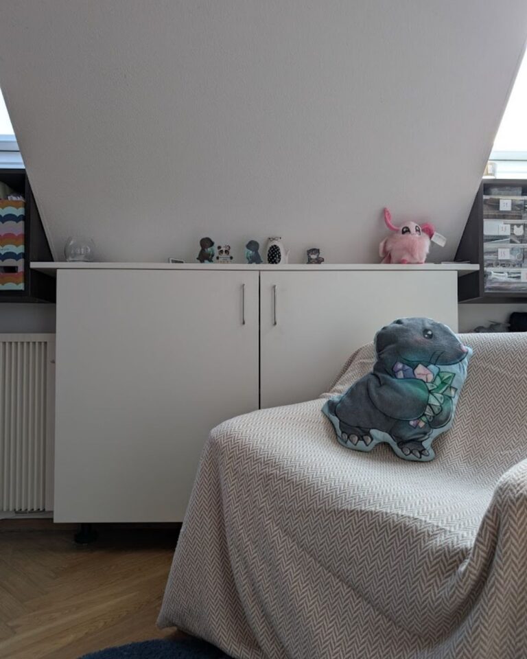 Ein gemütlicher Sessel vor einem Regal mit einer riesigen Auswahl an bunten Wollknäueln, bereit für ein neues Häkelprojekt