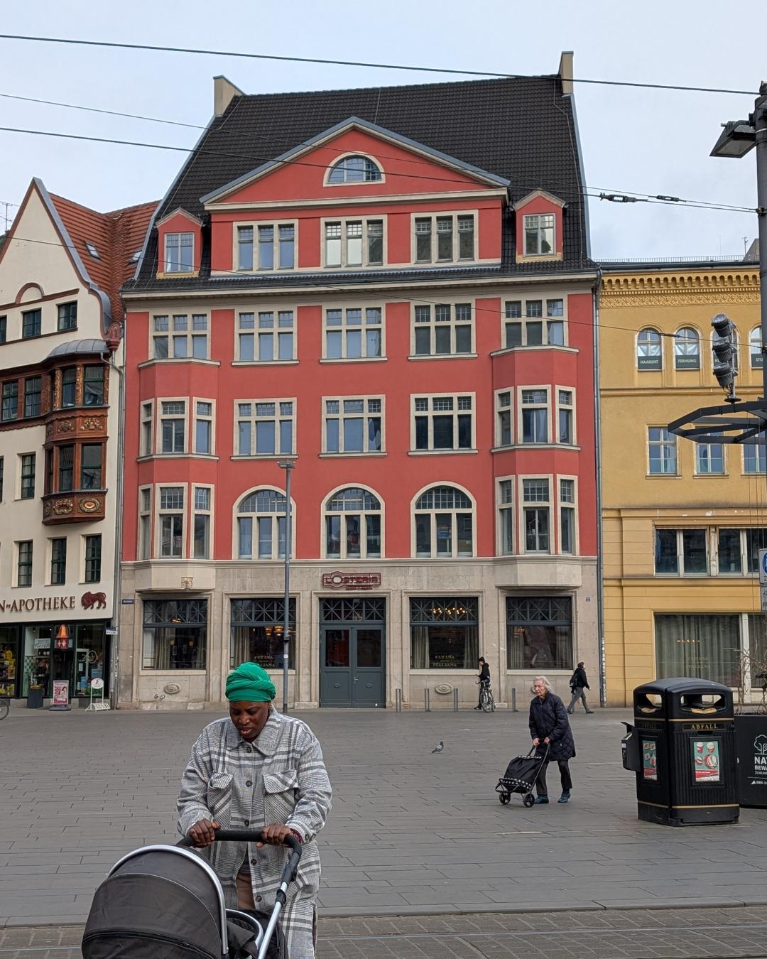 Detailansicht der neogotischen Fassade des Stadthauses am Marktplatz in Halle (Saale) mit großen Maßwerkfenstern und Wappenverzierung.