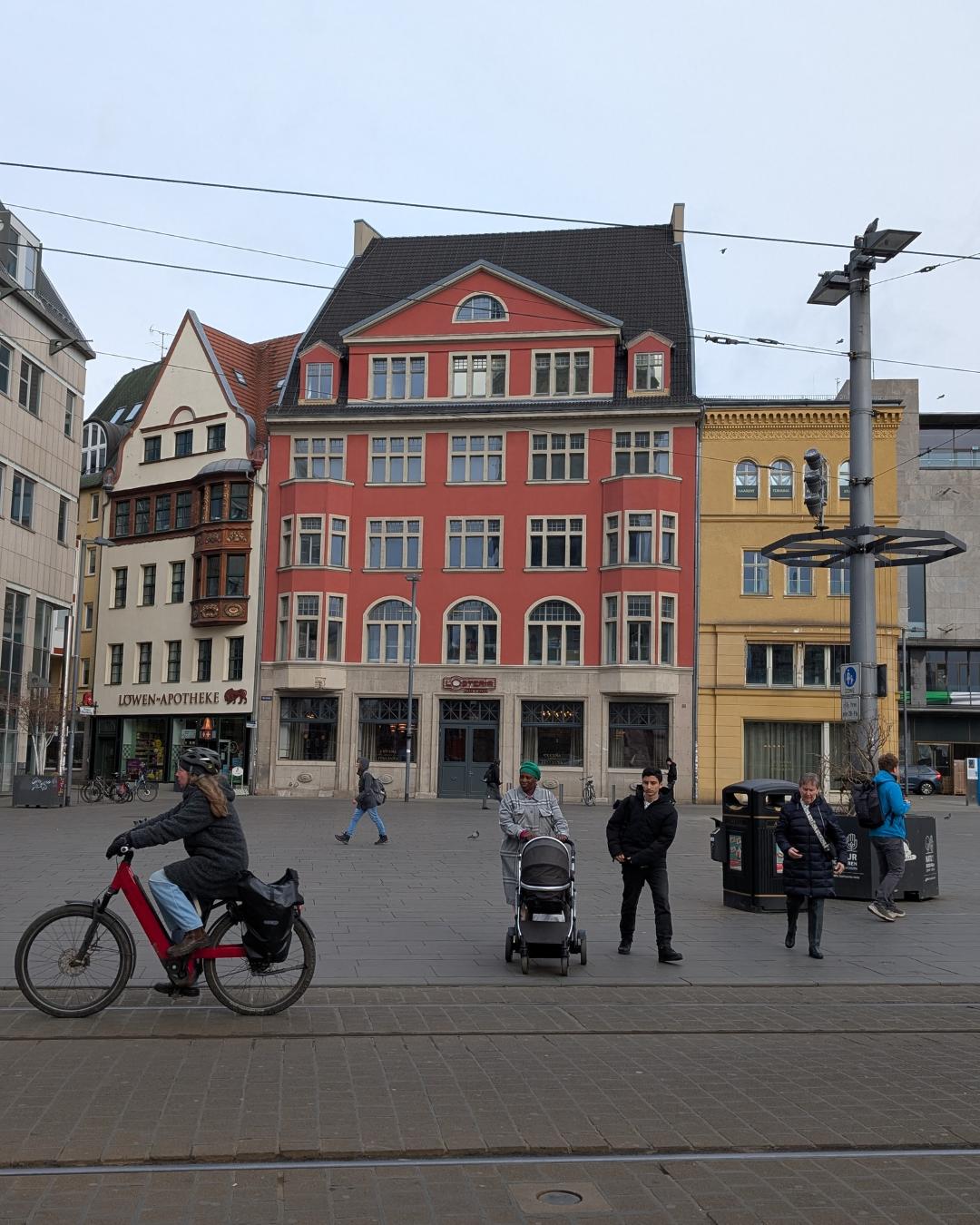 Detailansicht der neogotischen Fassade des Stadthauses am Marktplatz in Halle (Saale) mit großen Maßwerkfenstern und Wappenverzierung.